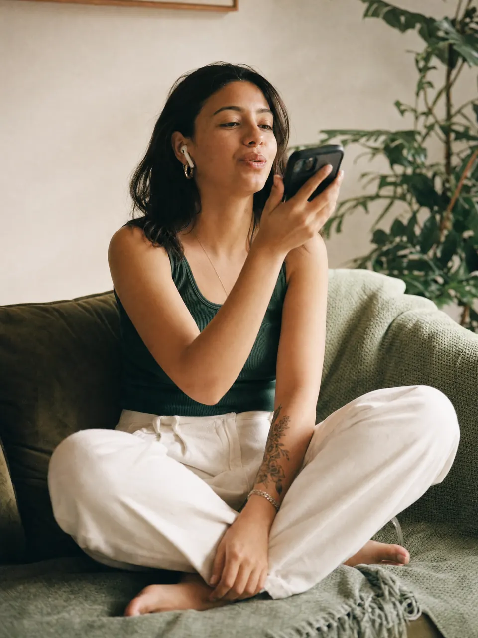A candidate at home on her sofa, answering interview questions on her phone